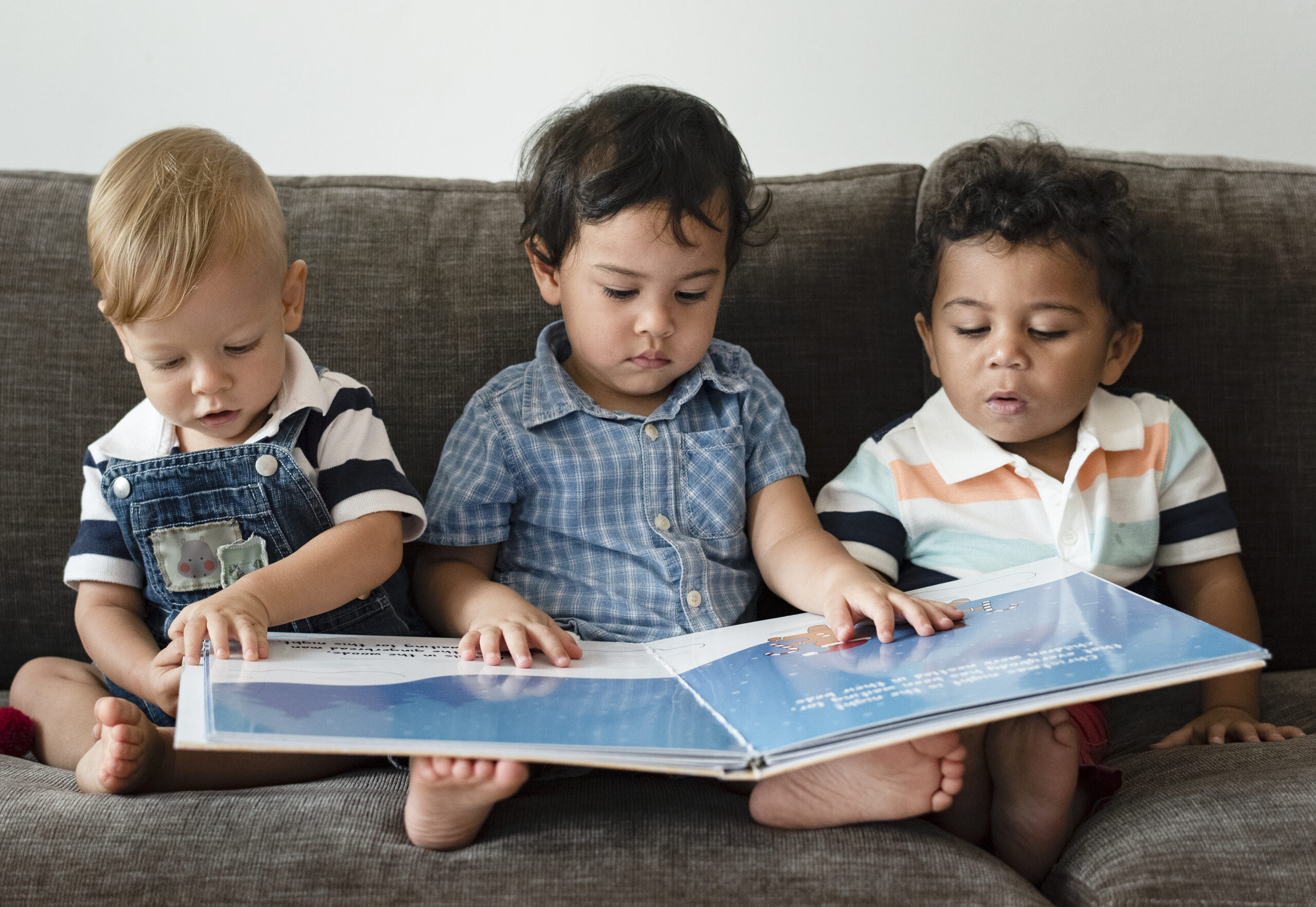 Three little boys reading