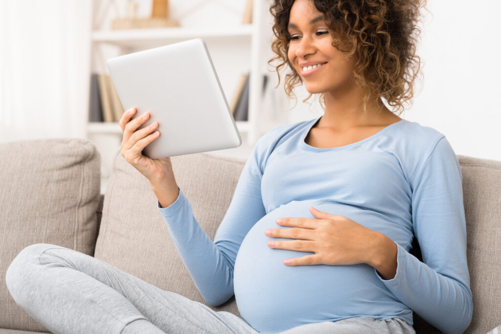 Pregnant woman reading on a digital tablet